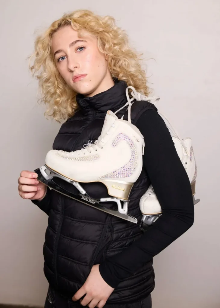 Marta's headshot with ice skates slung over her shoulder